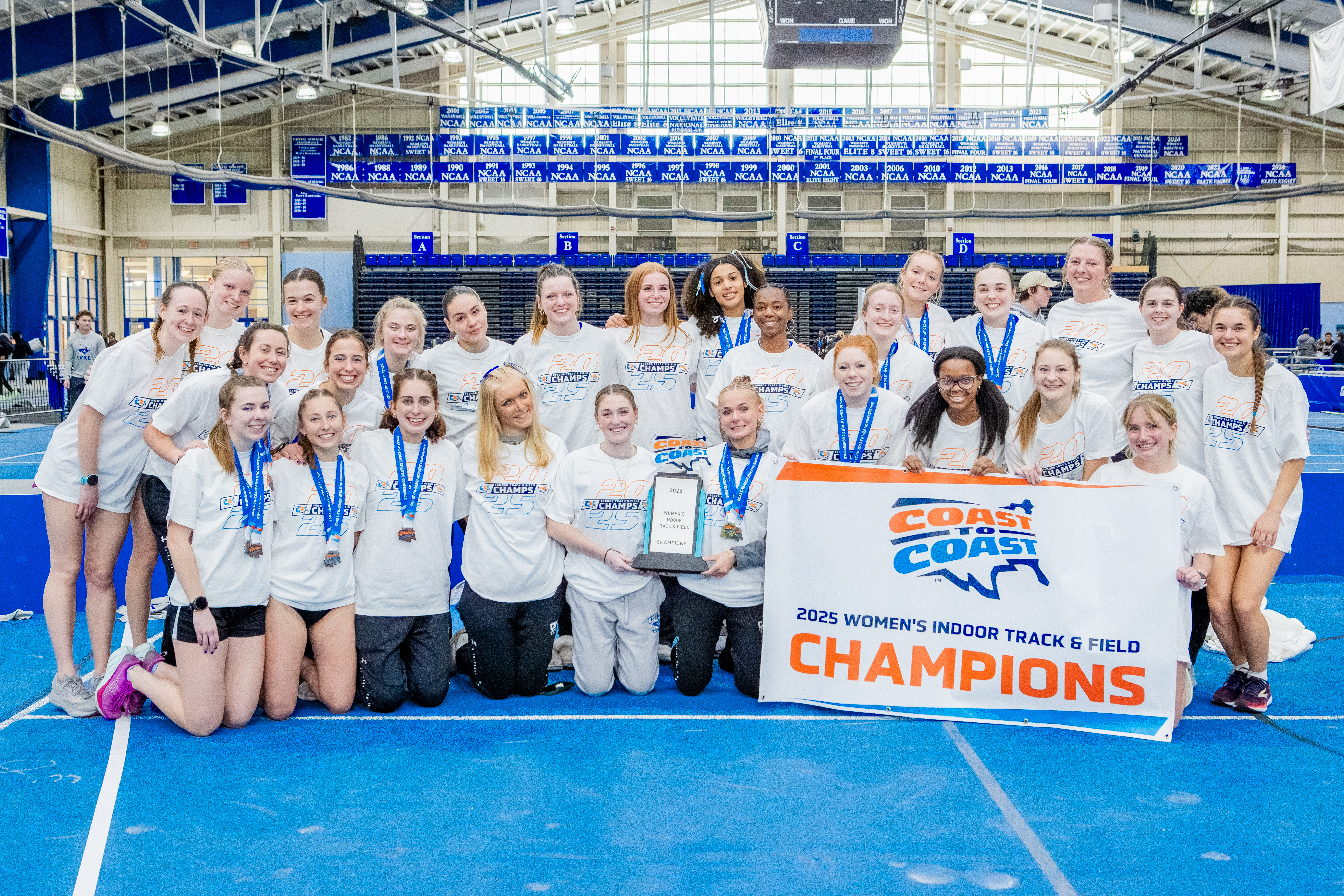 Photographs of the Track & Field and Cross Country Team holding up the championship banner
