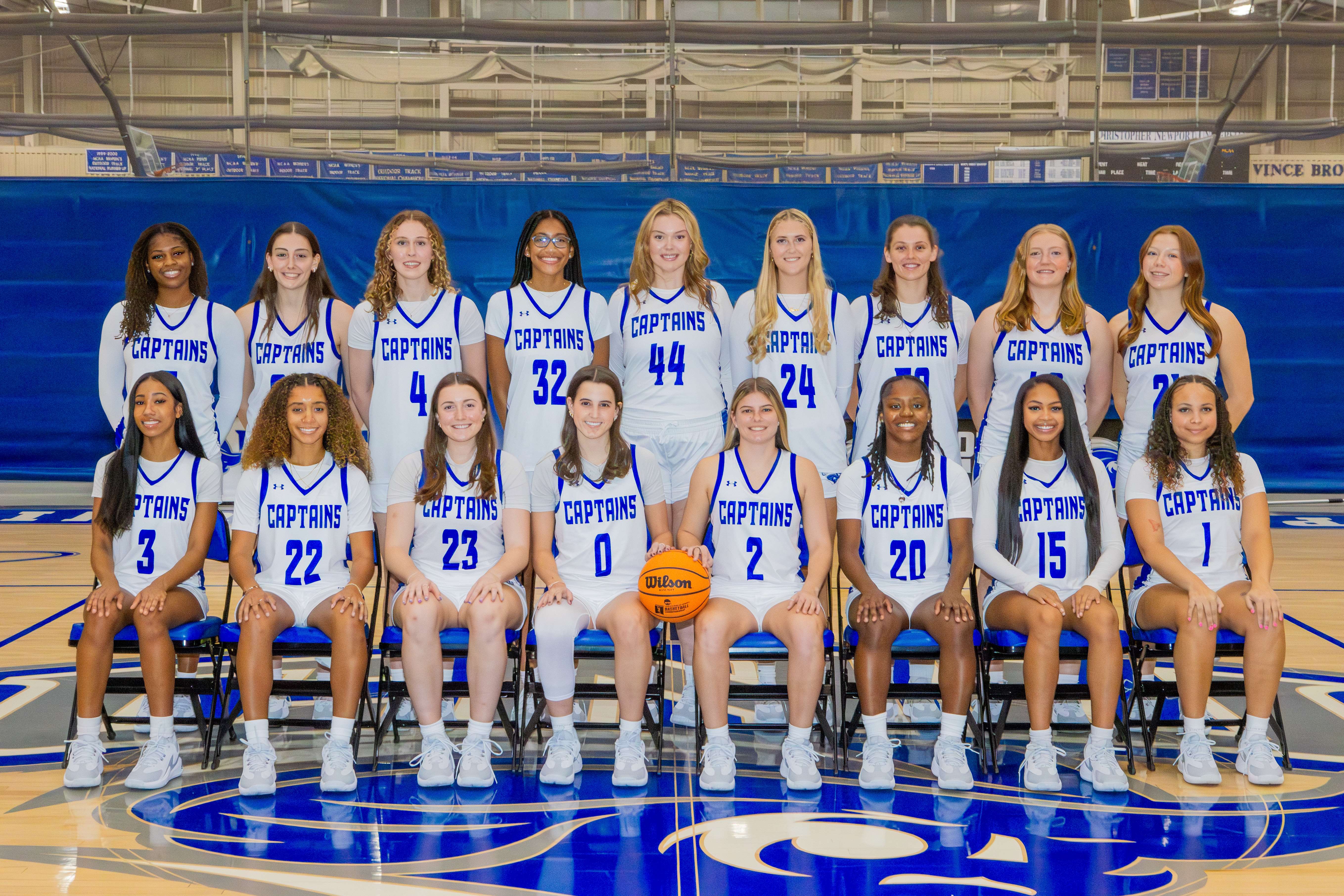 Photograph of the Women's Basketball team holding up the champions banner